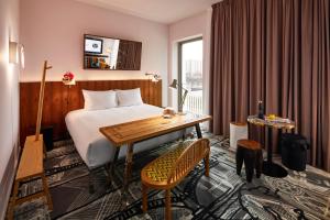 卢森堡Mama Shelter Luxembourg的配有一张床、一张书桌和一扇窗户的酒店客房