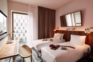 卢森堡Mama Shelter Luxembourg的酒店客房设有两张床和窗户。