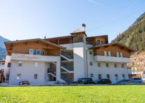 迈尔霍芬423 - Penthouse apartment centrum Mayrhofen near ski area的前面有汽车停放的建筑