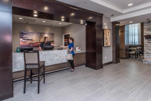 查尔斯顿Staybridge Suites Charleston - Mount Pleasant, an IHG Hotel的站在酒店大堂柜台的女人
