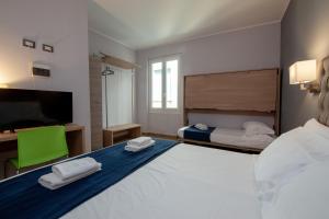 热那亚甘智亚娜酒店的一间卧室配有一张大床和一台平面电视