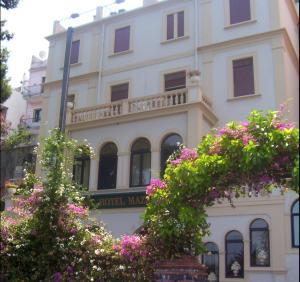 陶尔米纳马扎罗乔尼克的酒店的前面有粉红色花的建筑