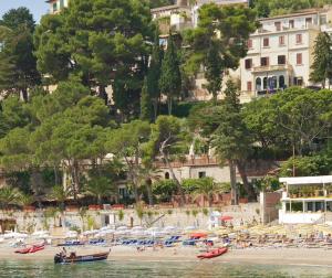 陶尔米纳马扎罗乔尼克的酒店的海水中有许多小船的海滩