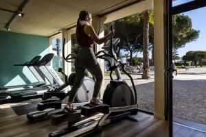 阿尔沃尔若昂二世佩斯塔纳度假酒店的一名在健身房跑步机上跑步的女人