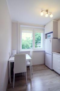 德鲁斯基宁凯Apartamentai Domeva的一间带桌子和白色冰箱的小厨房