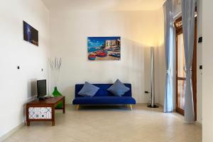 焦维纳佐La Rotonda - Casa vacanze的客厅配有蓝色的沙发和电视