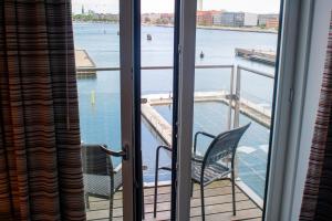 哥本哈根哥本哈根岛酒店的阳台配有两把椅子,享有水景