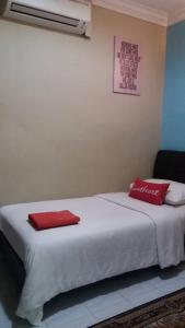 PakaManja Inn, Paka的床上有两个红色枕头的床