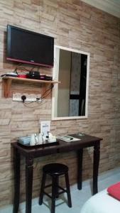 PakaManja Inn, Paka的一张带镜子的桌子和墙上的电视