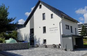 维林根Appartementhaus kleines Glück &MeineCardPLUS的白色的建筑,旁边标有标志