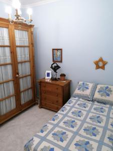 卡拉蒙特Atico的一间卧室配有一张床和一个木制梳妆台