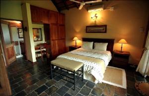 马里兰Khandizwe Kruger Villa的一间卧室配有一张床、两张桌子和两盏灯。