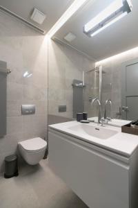 维尔纽斯APARTAMENTAI LEMBERGAS的白色的浴室设有水槽和卫生间。