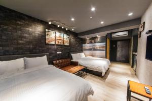 罗东镇罗东夜市坦智能旅店 的一间卧室设有两张床和砖墙
