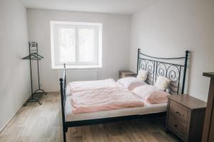 伊赫拉瓦Apartmán v přírodě pro 4 osoby的一间卧室配有一张带粉色床单的床和一扇窗户。