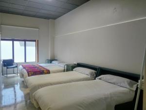 庞特维德拉Acolá Rooms的一间设有四张床和椅子的房间