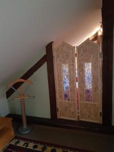 斯米扎尼索鲁多斯-斯皮斯基卢维多姆旅馆的一间设有两扇木门和彩色玻璃的房间