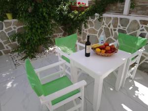 安迪帕罗斯岛Nicolas Antiparos的一张带一碗水果和一瓶葡萄酒的白色桌子