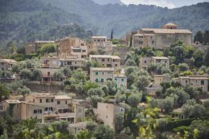 德阿La Residencia, A Belmond Hotel, Mallorca的山丘上的一个村庄,有房子和树木