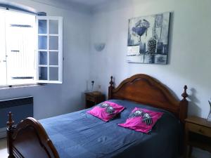 圣特罗佩Chambre Privée dans Villa Provençale的一间卧室配有带粉红色枕头的床。