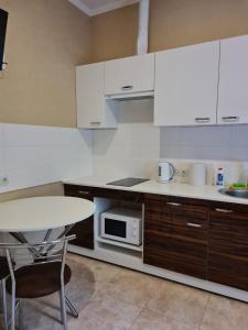 PivdenneACAPULCO的厨房配有白色橱柜、桌子和微波炉