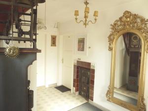 莱茵河畔威尔Pension Zur Rose的一间设有镜子和壁炉的客房