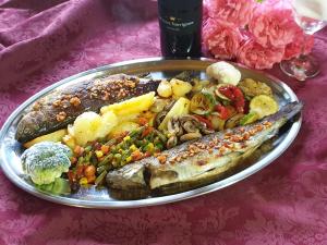 普利特维采湖畔山布雷扎酒店的桌上一盘带鱼和蔬菜的食物