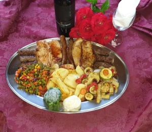 普利特维采湖畔山布雷扎酒店的餐桌上放着一盘带香肠和蔬菜的食物
