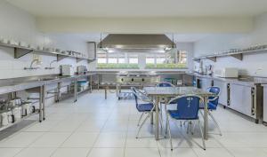 福塔莱萨梦幻汽车旅馆（仅限成人）的一个带桌子和蓝色椅子的大厨房