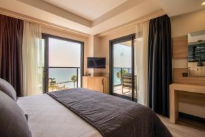 古泽尔坎里MAIA Luxury Beach Hotel & Spa的一间卧室设有一张床,享有海景
