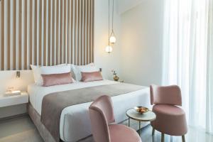 干尼亚Mirabile Luxury Suites的配有一张床和一把椅子的酒店客房