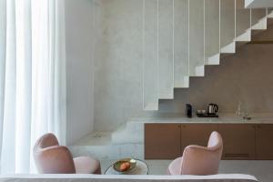 干尼亚Mirabile Luxury Suites的一间带两把椅子和楼梯的客厅