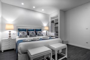 佩尼契Ilheu 25 Peniche House的白色卧室配有一张带蓝色枕头的大床