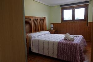 里瓦德塞利亚La casina de ribadesella的一间卧室配有一张带紫色毯子的床和窗户。