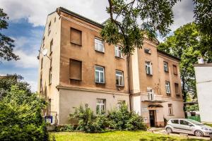 卢布林Apartament 2 pokoje Lublin Centrum ulica Narutowicza的一座古老的建筑,前面有停车位