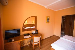 拉布Villa Tamaris的酒店客房配有一张桌子、一张床和一台电视