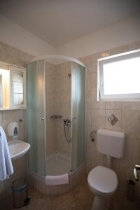 拉布Villa Tamaris的带淋浴、卫生间和盥洗盆的浴室