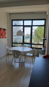 马贝拉Skol 235B by Completely Marbella的配有大窗户的客房内的白色桌椅