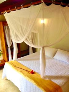 马劳Pousada Mahat的一间卧室配有一张带天蓬的白色床