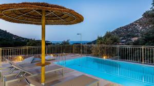 巴利恩Summer Villas Crete的一个带遮阳伞和游泳池的庭院