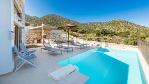 巴利恩Summer Villas Crete的庭院内一个带椅子和遮阳伞的游泳池