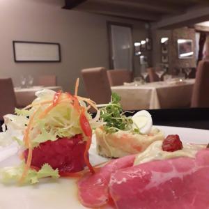 BossolascoAl biancospino- Camere- Ristorante的桌上一盘带肉和沙拉的食物