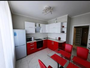 敖德萨Apartments Lutsdorf的厨房配有红色橱柜和红色椅子
