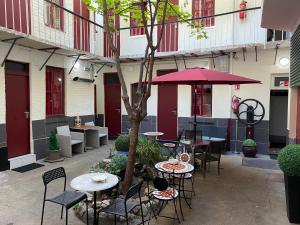 勒瓦卢瓦-佩雷舍瓦利尔酒店的庭院配有桌椅和一棵树