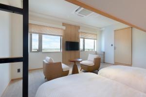 石垣岛THIRD ishigakijima的酒店客房带两张床、椅子和窗户