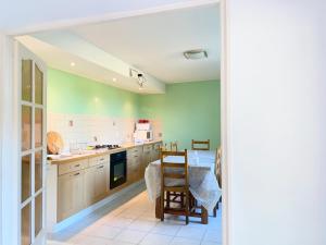 瓦里勒斯Spacieuse maison dans un parc privée的厨房设有绿色的墙壁和桌椅