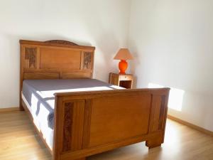 瓦里勒斯Spacieuse maison dans un parc privée的一间卧室配有一张木床和一张带台灯的桌子
