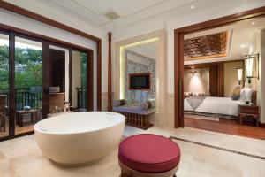 景洪市西双版纳洲际度假酒店的带浴缸的浴室和1间带1张床的卧室