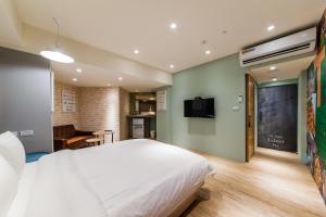 罗东镇Talent Hotel E系列的卧室配有白色的床和平面电视。
