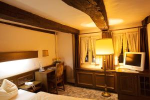 布伦瑞克里特尔圣乔治酒店的一间卧室配有一张床和一张书桌及电视